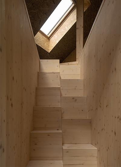 Eine ungewöhnliche, mittig geteilte Holztreppe, verbindet Erdgeschoss und ersten Stock des Holz-Idylls. (Bild: Petr Polák)