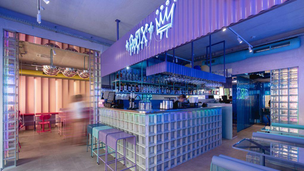 FoodX Pznan: Theke mit Glasbausteinen, Barhockern und Neonschrift