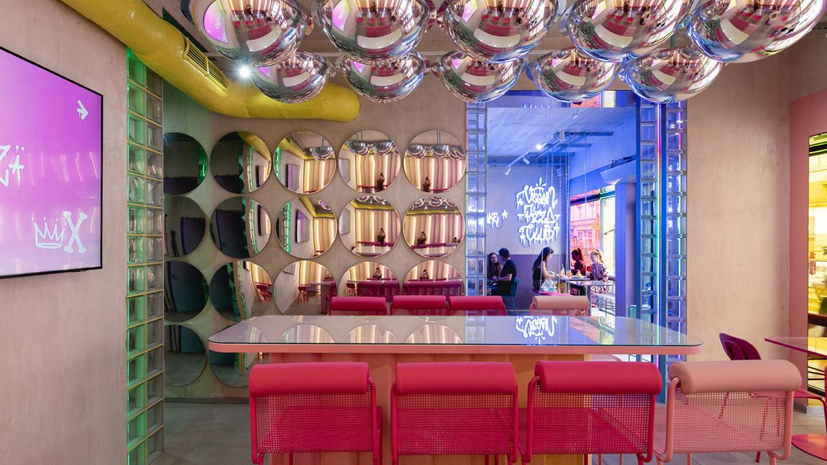Innenansicht mit Street Mirrors an Decke und Wänden sowie roten Metallstühlen an den Tischen
